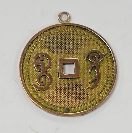 A Chinese 14k cash shaped charm, inscribed 'Qianlong tong bao', 25mm, 4.2 grams. Condition - fair